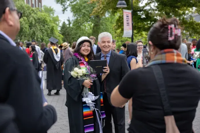 A student smiles with a family member during Commencement